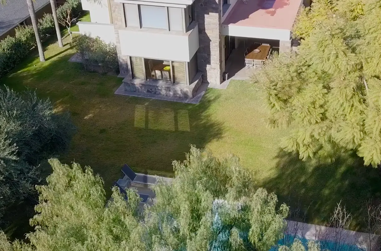 Vista aérea del jardín maduro y la piscina propia